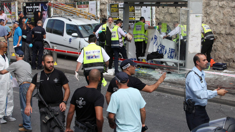 Israeli Zaka volunteers cover the body of an Israeli victim (C) after a Palestinian man drove into a bus stop and carried out a stabbing attack in a Jerusalem ultra-Orthodox Jewish neighbourhood on October 13, 2015. The Jerusalem attack came after a Palestinian stabbed and wounded a passerby north of Tel Aviv before being restrained by civilians in the area. AFP PHOTO / GIL COHEN-MAGEN        (Photo credit should read GIL COHEN MAGEN/AFP/Getty Images)